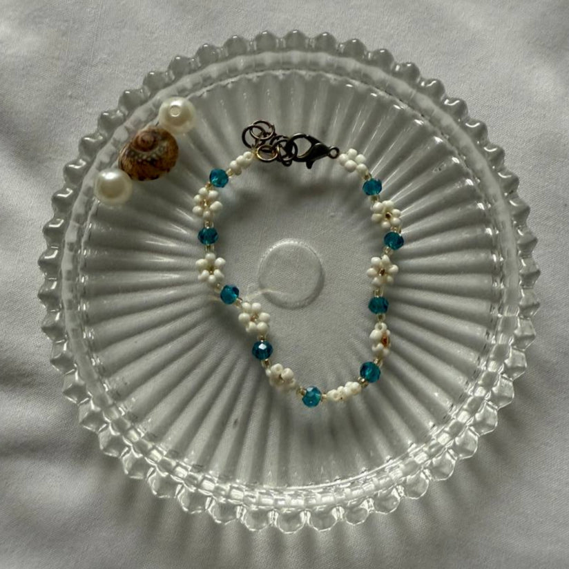 Perlenarmband mit weißen Blumen und türkisen Kristallen