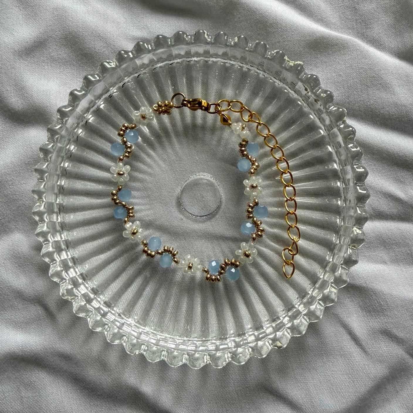 Perlenarmband mit weißen Blumen und blauem Wellenmuster