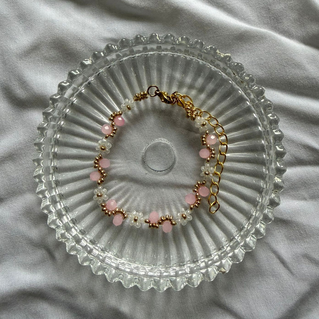 Perlenarmband mit weißen Blumen und rosanem Wellenmuster