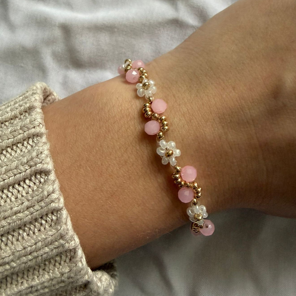 Perlenarmband mit weißen Blumen und rosanem Wellenmuster