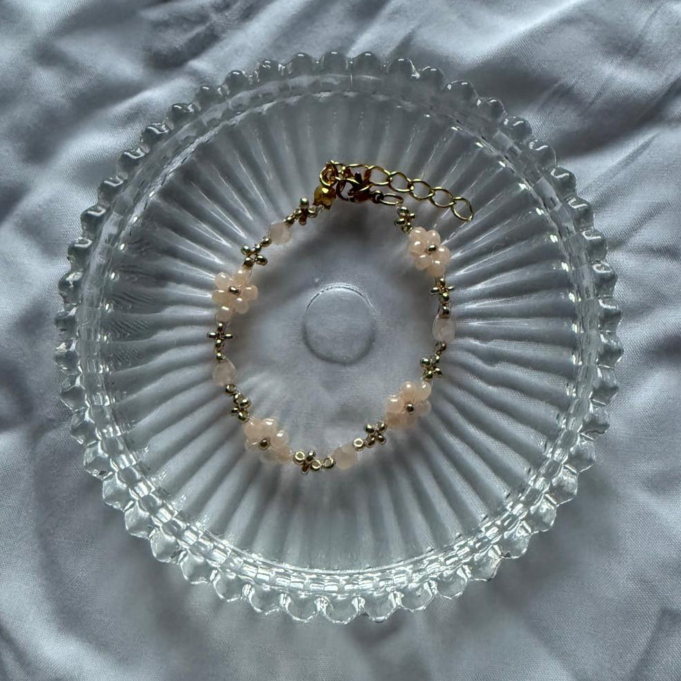 Perlenarmband mit orangenen Blumen und goldenen Details