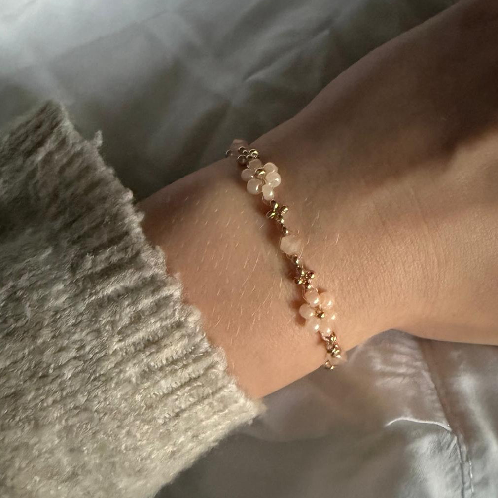 Perlenarmband mit orangenen Blumen und goldenen Details