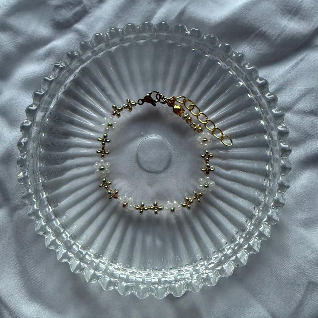 Perlenarmband mit weißen Blumen und goldene Details