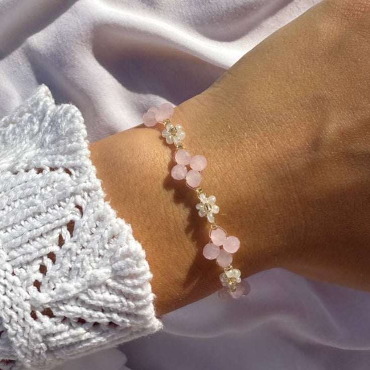 Perlenarmband mit rosanen Kristallen und weißen Blumen