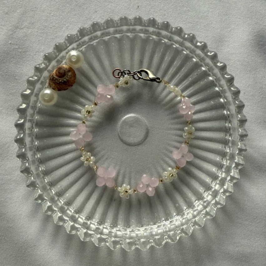 Perlenarmband mit rosanen Kristallen und weißen Blumen