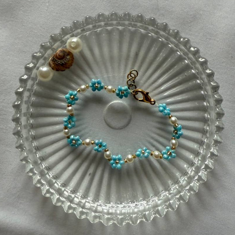 Perlenarmband mit blauen Blumen und weißen Perlen