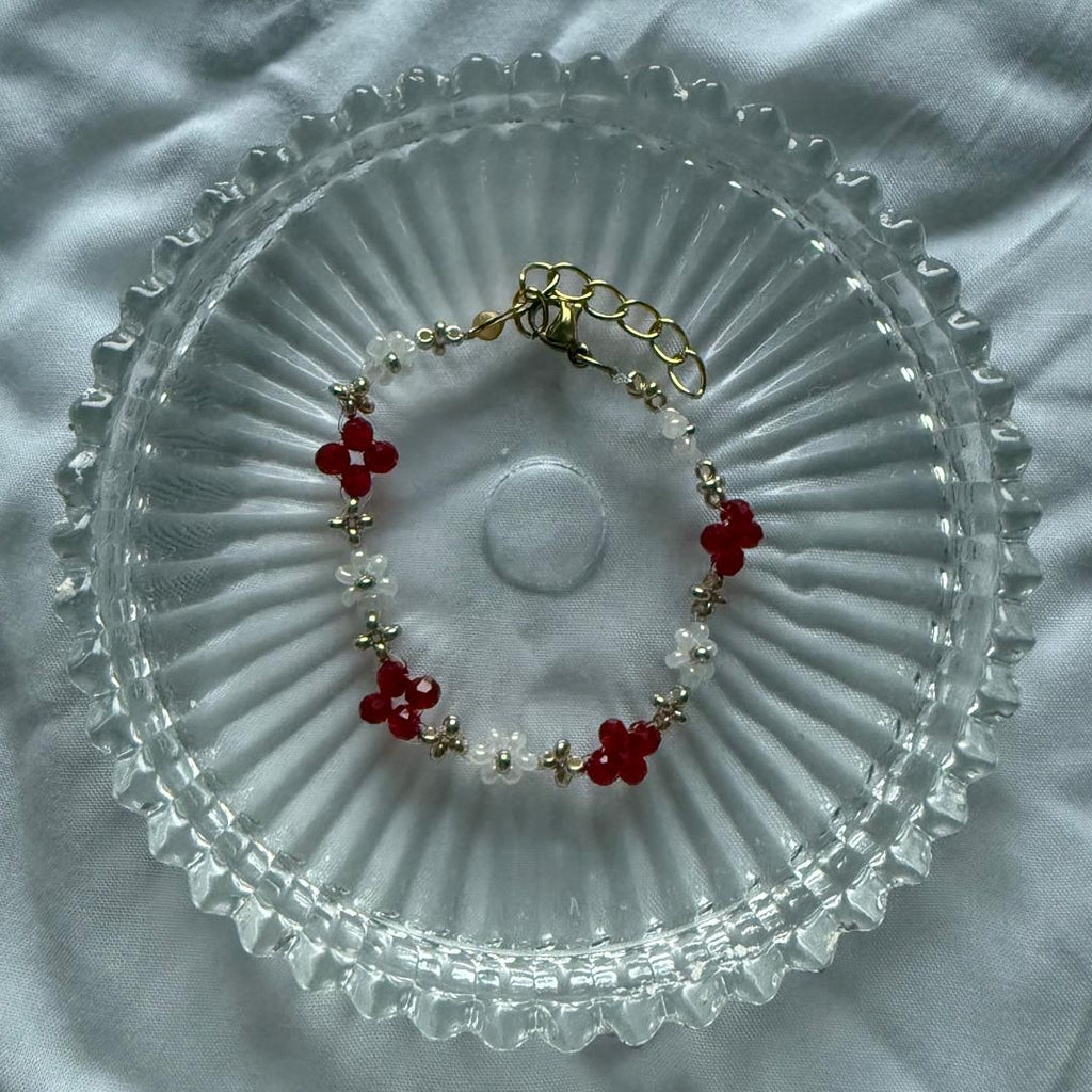 Perlenarmband mit roten Kristallen und weißen Blumen