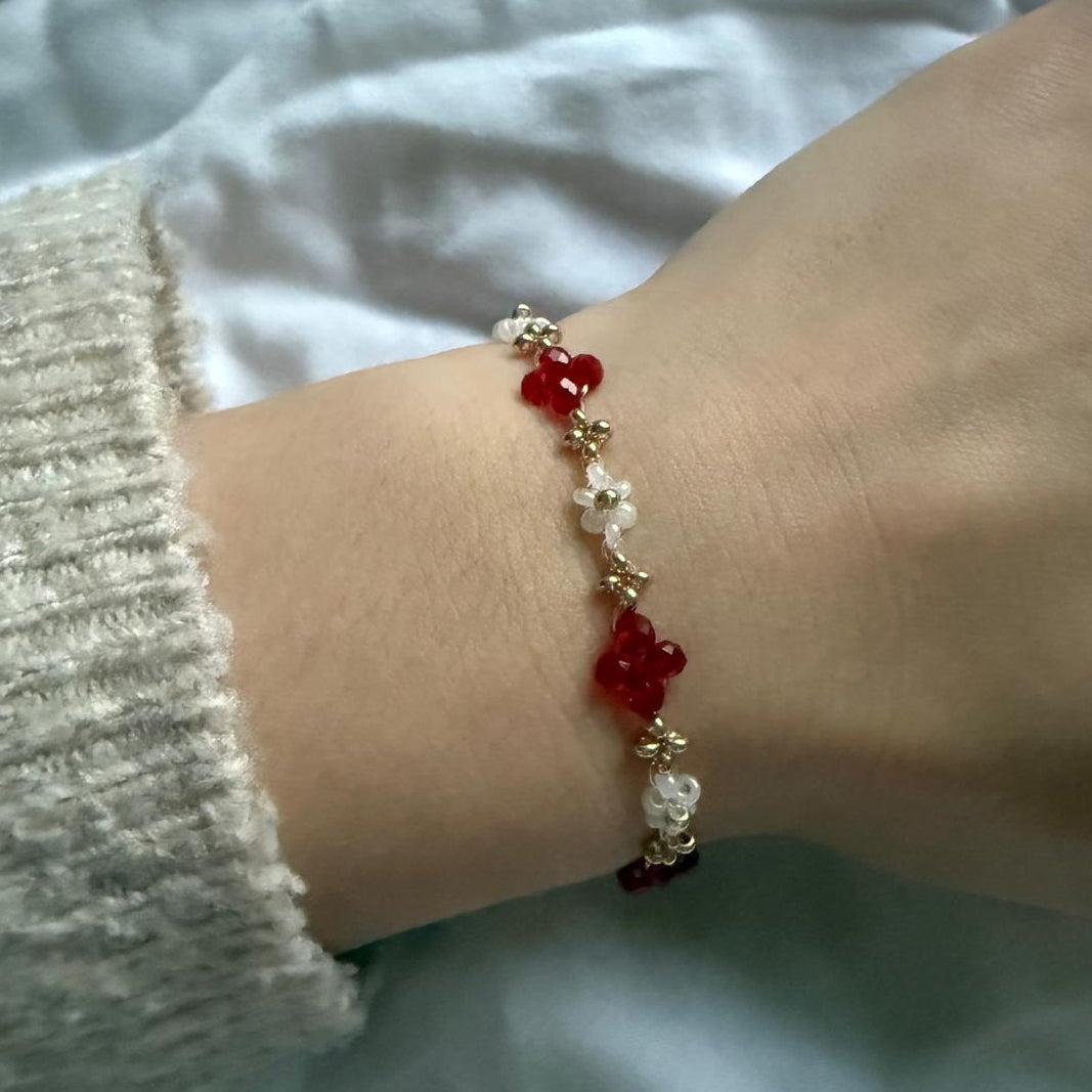 Perlenarmband mit roten Kristallen und weißen Blumen